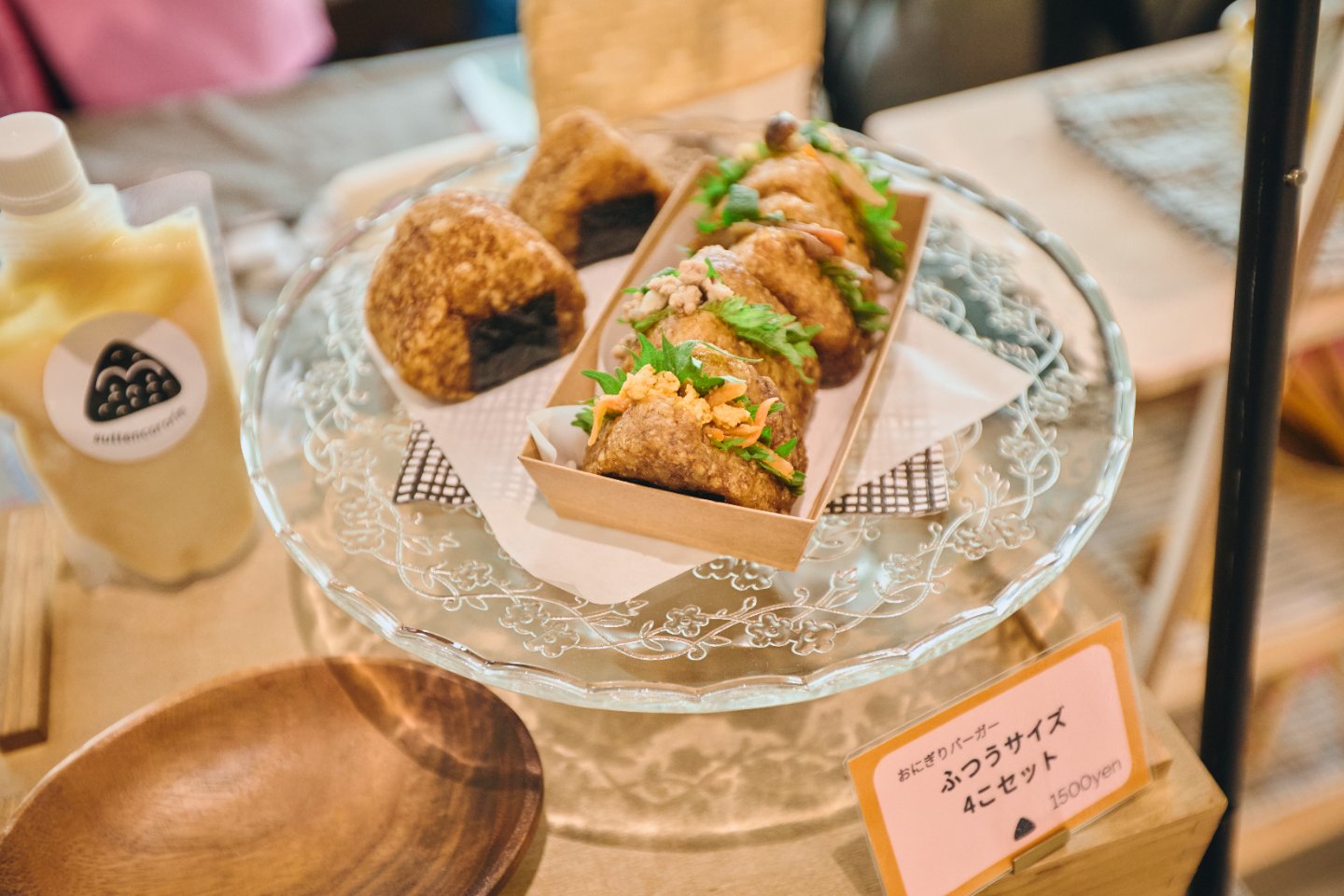 玄米揚げおにぎり（左）は圧力鍋で炊いた玄米のおにぎりを醤油にくぐらせ、米油でしっかり揚げたもの。外はカリカリ、なかはもっちり。白米に比べて食物繊維が豊富で、少量でも腹持ちが抜群。おにぎりバーガー（右）の一番人気は、クミンやコリアンダーなどのスパイスを効かせた豚ミンチのスパイス炒め